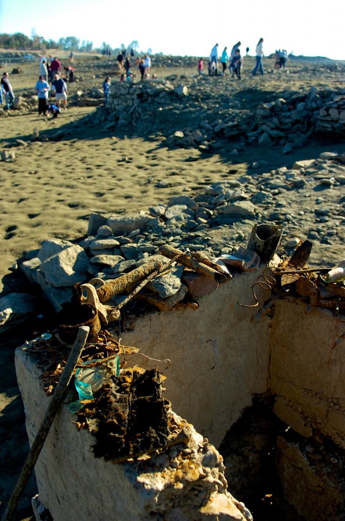 Rusty nails, fence parts, glass and other items are displayed on the exposed foundations of Mormon Island. 